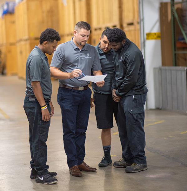 a training manager holding a clipboard teaching new employees